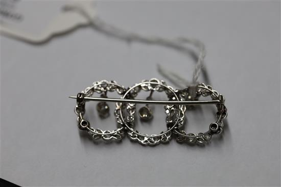 A 1920s white gold and diamond set interlocking triple circle openwork drop brooch,